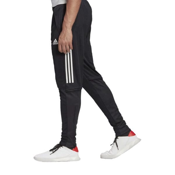 Man wearing black adidas pants with white stripes.