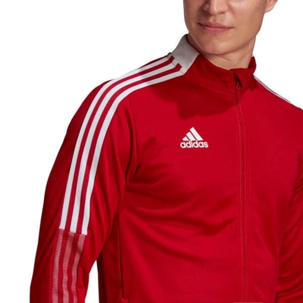 Red Adidas track jacket with white stripes.