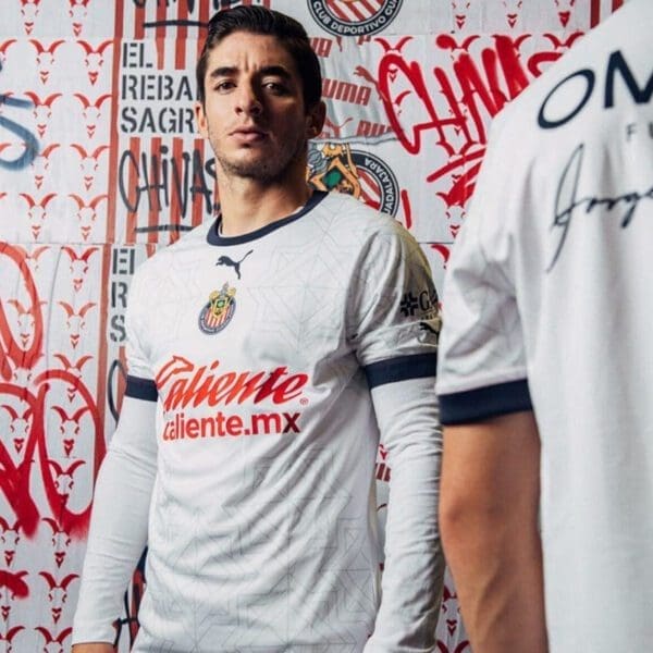 Man in white soccer jersey with red logo.