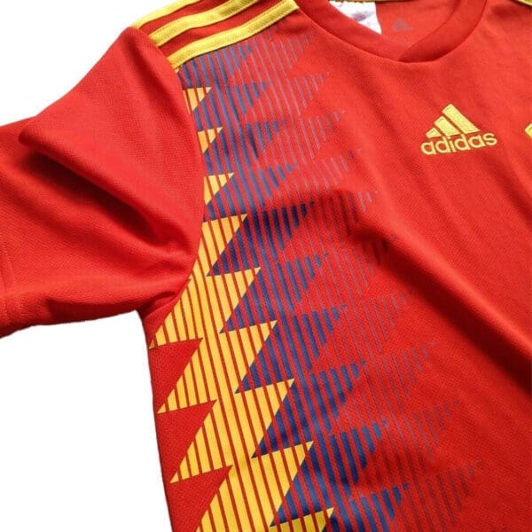 Red Adidas soccer jersey with yellow stripes.