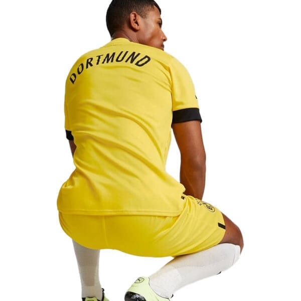 Man wearing a yellow Dortmund soccer jersey.