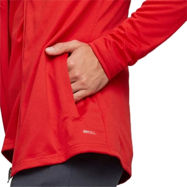 Red zip-up jacket with a hand in the pocket.