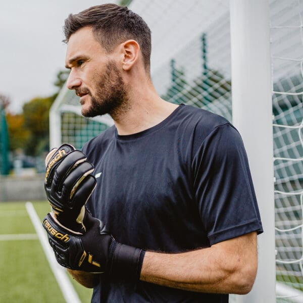 Man wearing black soccer gloves and jersey.