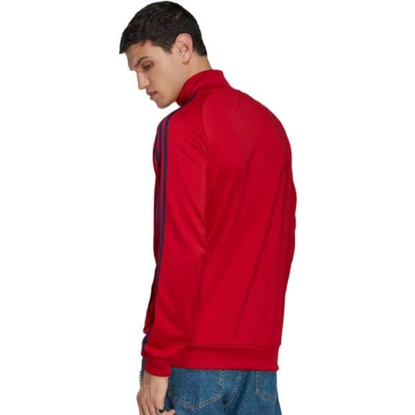 Man in red track jacket with blue stripes.