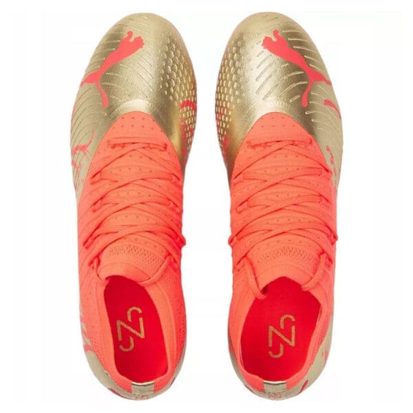 Gold and pink Puma soccer cleats.