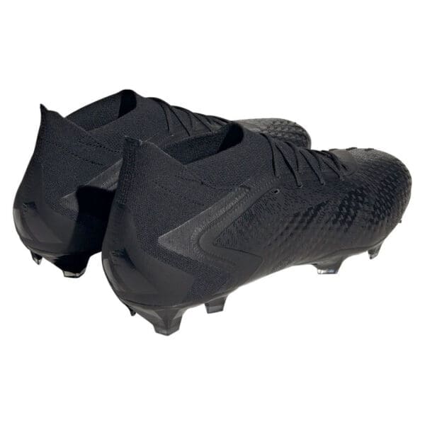 Black Adidas soccer cleats on white background.