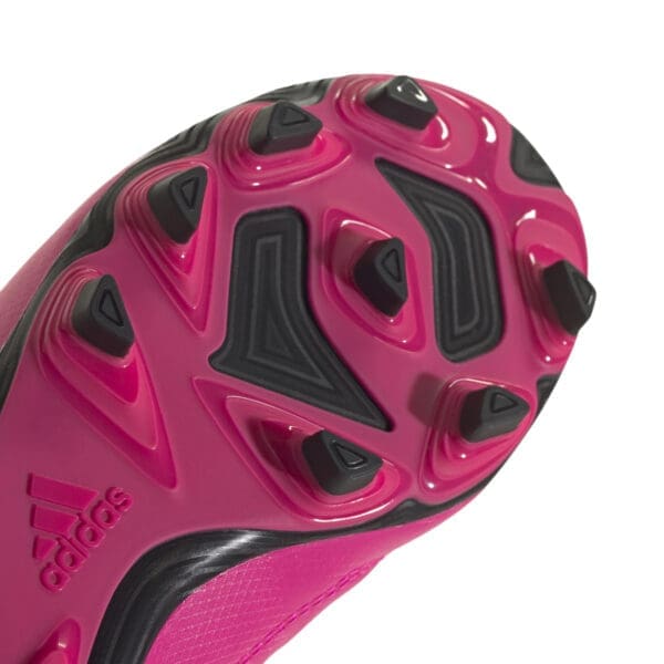 Pink Adidas soccer cleat sole close-up.