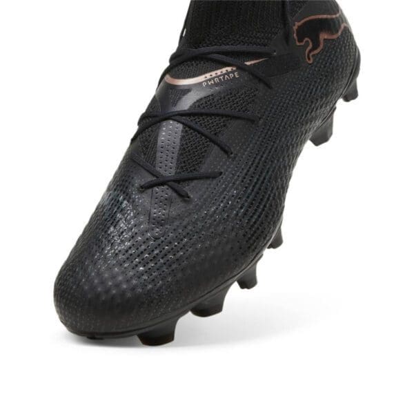 Black Puma football boot with gold accents.