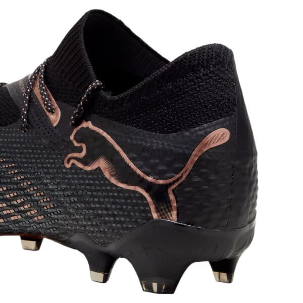 Black and rose gold Puma soccer cleats.