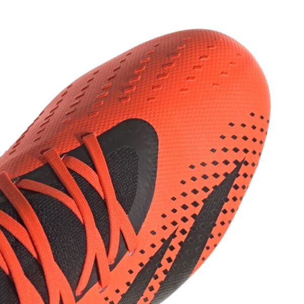 Close-up of an orange and black soccer cleat.