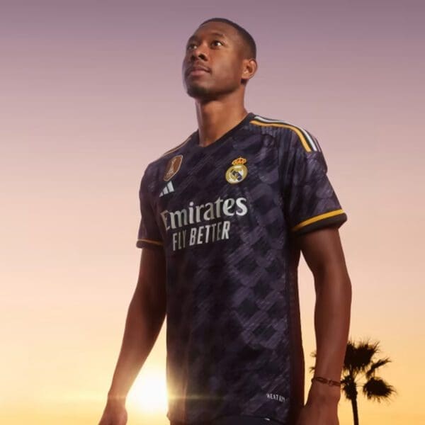 Man wearing Real Madrid jersey with sunset background.