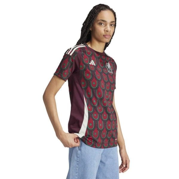 Woman wearing a red and green patterned Adidas shirt.