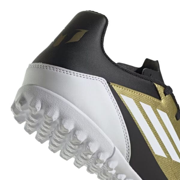 Black and gold Adidas soccer shoe.