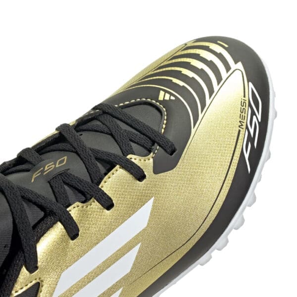 Close-up of a gold and black Adidas Messi soccer cleat.