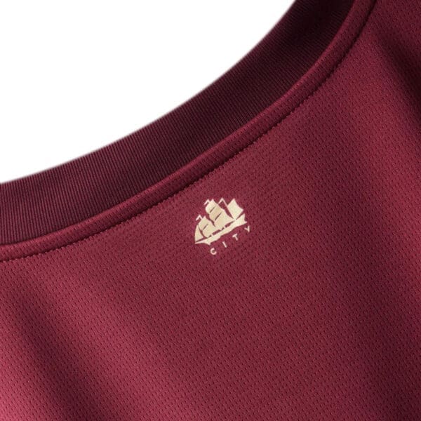 Burgundy shirt with ship logo.