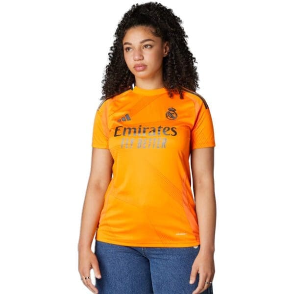 Orange Real Madrid soccer jersey with logo.