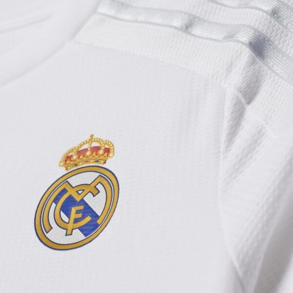 Real Madrid crest on white shirt.