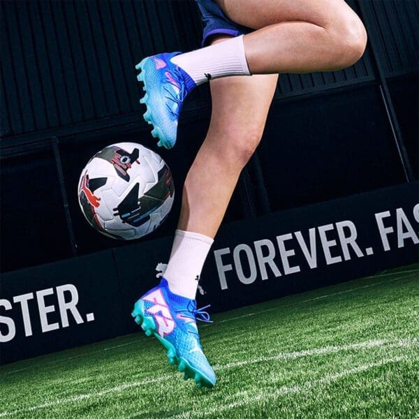 Soccer player with blue cleats, kicking ball.