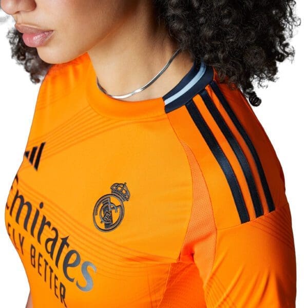 Woman wearing orange Real Madrid jersey.