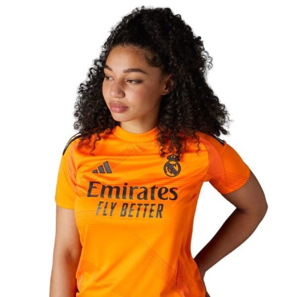 Woman wearing an orange Real Madrid jersey.