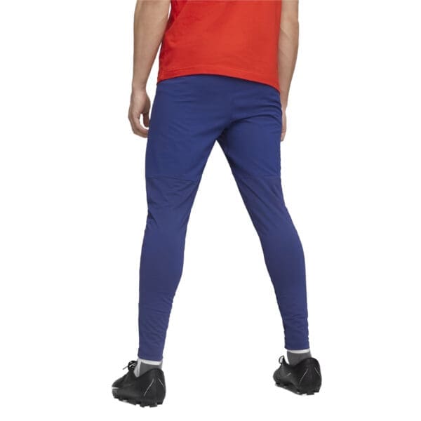 Man wearing blue athletic pants and red shirt.