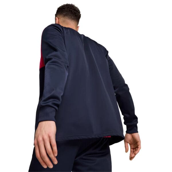 Man in blue and red tracksuit, back view.