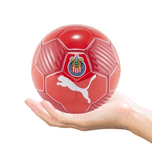 Red soccer ball with Chivas logo in hand.