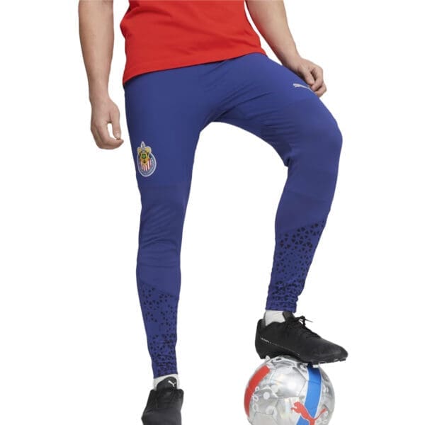 Man wearing blue soccer pants and a red shirt.