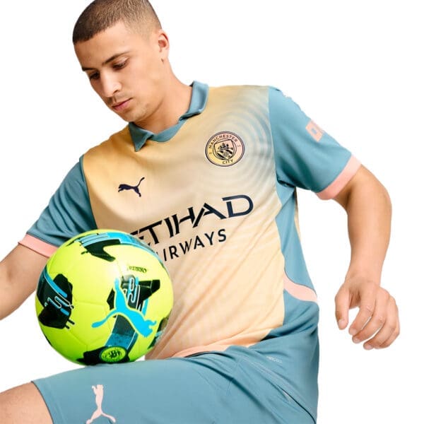 Man in Manchester City jersey with a soccer ball.