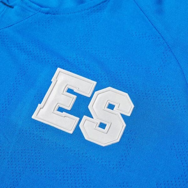 White "ES" on blue jersey fabric.