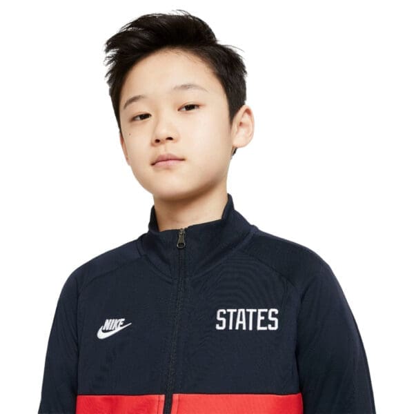 Boy wearing a black Nike States jacket.