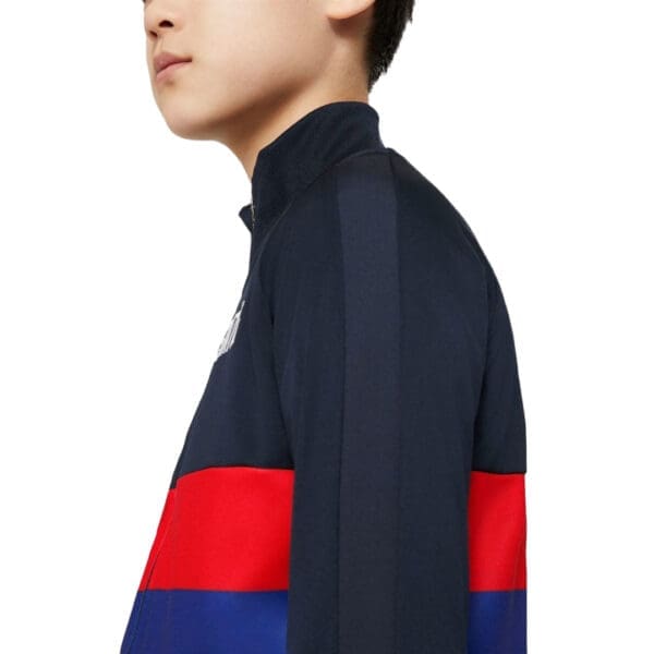 Boy wearing a navy blue and red jacket.