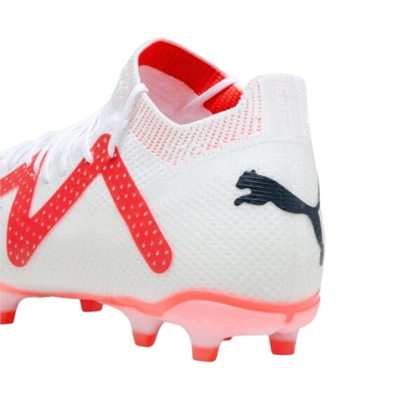 White Puma soccer cleats with red accents.