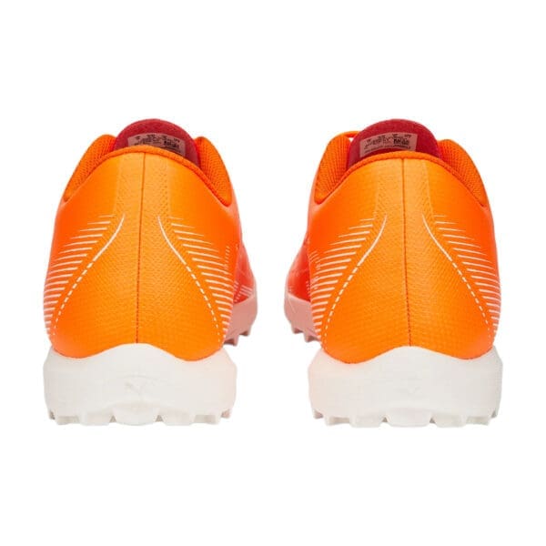 Orange and white athletic shoes, back view.