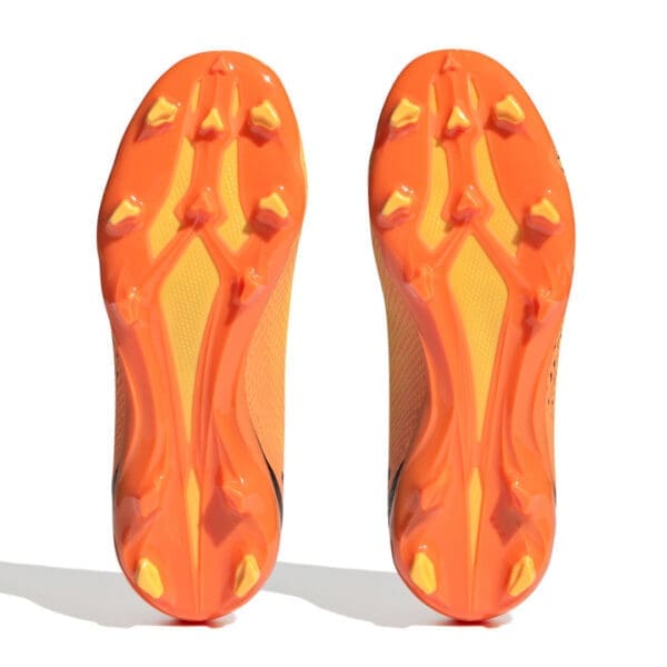 Orange and yellow soccer cleats soles.