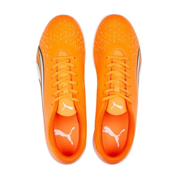 Orange Puma soccer cleats, top view.