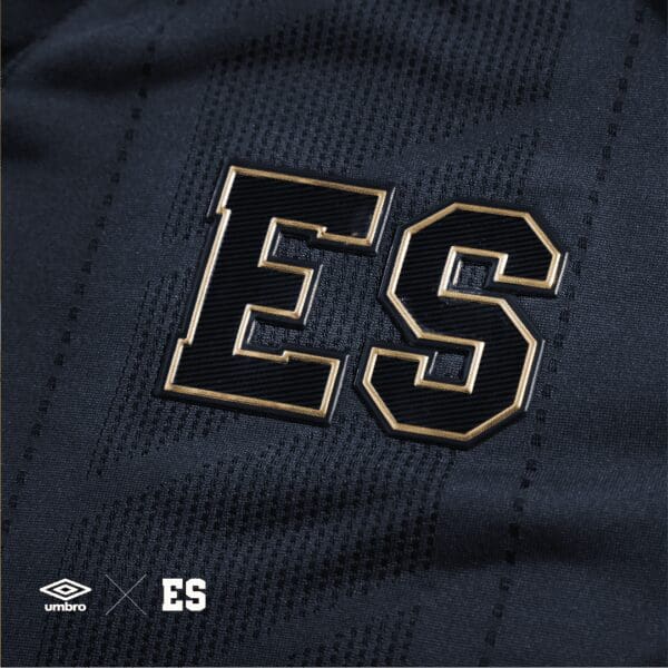 Black and gold "ES" patch on jersey.