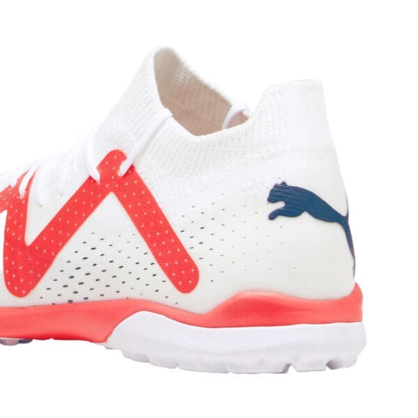 White Puma soccer shoe with red accents.