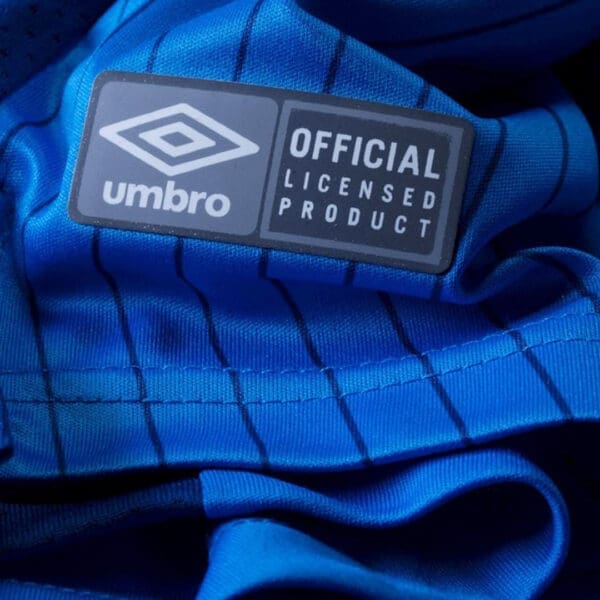 Umbro official licensed product on blue shirt.