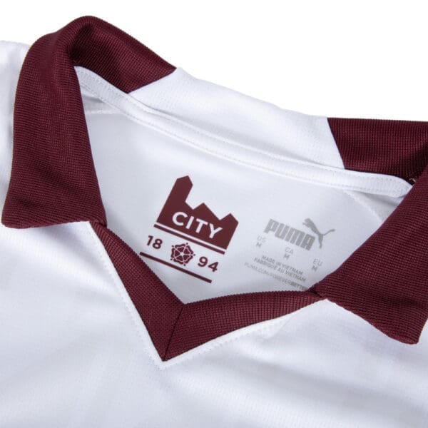 White soccer jersey with maroon collar and Puma logo.