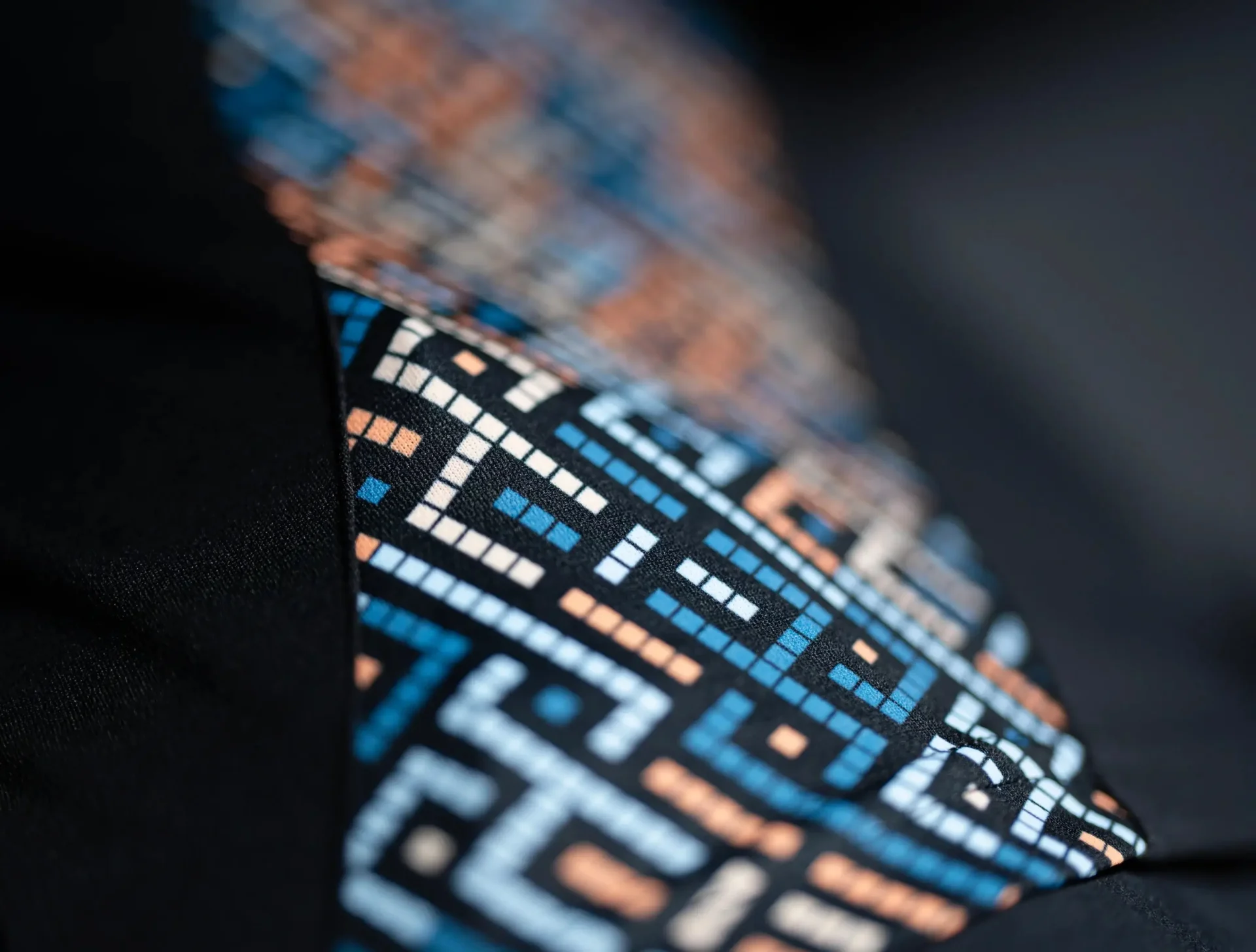 Colorful geometric pattern on fabric close-up.