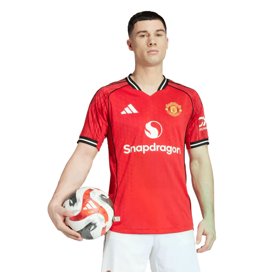 Soccer player in red jersey holding ball.