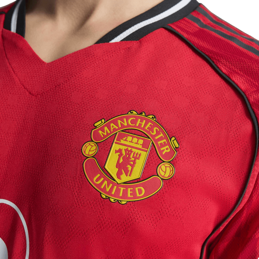 Manchester United logo on red football jersey.
