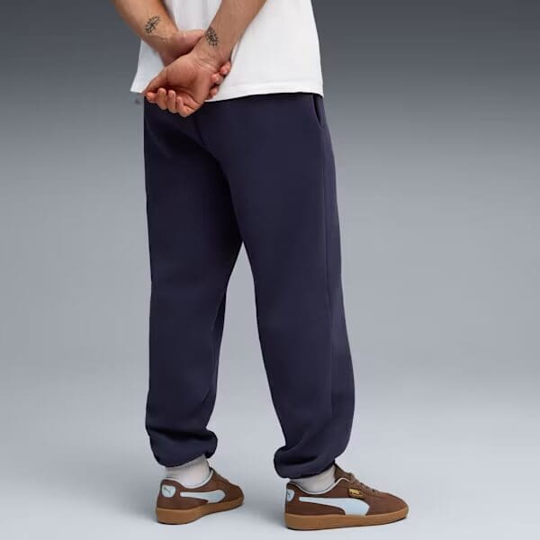 Person in joggers and sneakers, standing back.